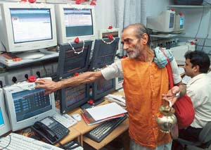 A priest blesses computer terminals at the Kolkata stock exchange before the federal Budget session. 