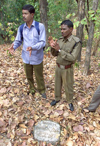 Indian forest guards show a stone
