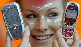 A model holds Siemens' SX1 and SL 55 mobile phones