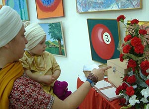 An American Sikh lady and her little kid watch a painting art exhibition