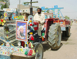 A man drives a tractor decorated with a poster of Osama bin Laden