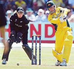 Australia's Andy Bichel drives as New Zealand wicketkeeper Brendon McCullum looks on