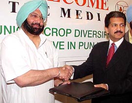 Anand Mahindra, MD, Mahindra Group, exchanges the file with the Punjab Chief Minister, Capt Amarinder Singh, after an agreement between Mahindra & Mahindra and the Punjab Agro, for the largest corp diversification programme in New Delhi 
