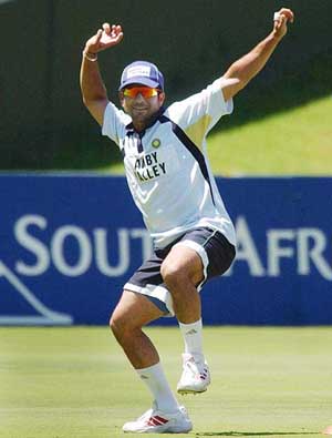 Sachin Tendulkar clowns as he imitates a colleagues bowling action 
