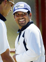 Sachin Tendulkar smiles as team physiotherapist Andrew Leipus walks past