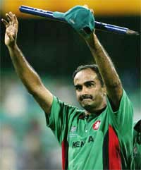 Kenyas Aasif Karim waves to the crowd as he walks off the field after their match against Australia