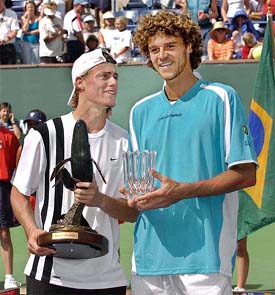 Top-seeded Lleyton Hewitt of Australia holds his trophy along with runner-up Gustavo Kuerten 
