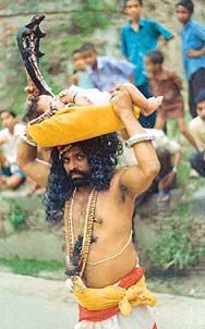 Performer seen as Vasudeva carrying the baby Krishna. Malda, Bengal.