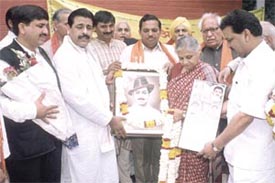 Chief Minister Sheila Dikshit being presented a photograph of Bhagat Singh at a function organised by the Kendriya Arya Yuvak Parishad at her residence