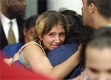 Fifteen-year-old Dana Pevia receives hugs from family members at Durham International Airport