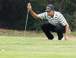 Indian golfer Jyoti Randhawa checks the ground