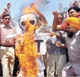 Members of the Sadar Bazar Traders Association burn a VAT effigy