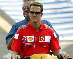 Germanys five-time Formula One world champion Michael Schumacher rides a bike with his manager Willy Weber