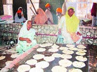 Women preparing parshada in the traditional style.