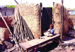 A child plays with his odds and ends, unmindful of the fire 