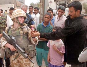 Samantha Sheppard, 28, a member of the 2nd Light Tank Regiment, is given a pink rose by an Iraqi man