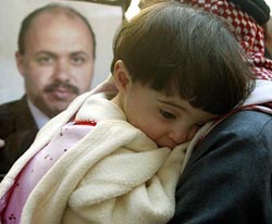 Fatima Ayyoub, 14-month-old daughter of Jordanian Al Jazeera correspondent Tareq Ayyoub, in front of a photograph of her father, killed in a missile attack in Baghdad