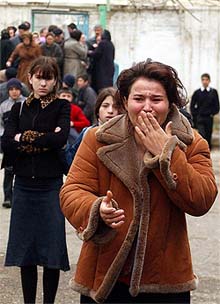 A woman bursts into tears as she walks to read the lists of children killed in a fire in a Russian boarding school for deaf children in Makhachkala
