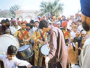 Devotees violate the Sikh code of conduct by dancing to popular filmi tunes in front of Gurdwara Nankana Sahib