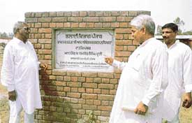 Representatives of the Vishav Guru Ravi Dass Mission pointing towards a foundation stone of the Dr B.R. Ambedkar Bhavan laid at Salem Tabri