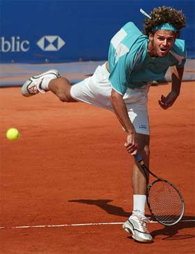 Gustavo Kuerten of Brazil returns the ball to Magnus Norman of Sweden