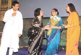 Abha Dalmiya of Samagam presents a bouquet to Mrs Kamla Advani.