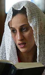 An Iraqi woman sings from a book of hymns at a Protestant church during a Good Friday service in central Baghdad 