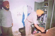 A policeman inspects an almirah after a robbery which took place in a house at Millergunj