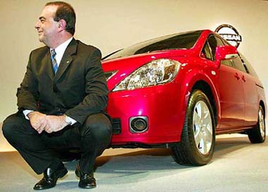 Nissan Motors Co. Chief Executive Carlos Ghosn poses in front of a new model Presage