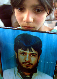 Kulsooma Mir, 8, holds a photograph of her missing father