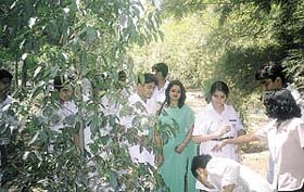 Schoolchildren watering plants on Earth Day at the Nehru Place Green Park in the Capital