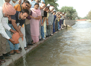Manu and Zannat, son and daughter of Balwant Gargi, immerse the ashes of their father in the Sirhind Canal near Bathinda on Friday.