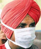 A porter at the Amritsar railway station wears a face mask to prevent the infection of SARS virus