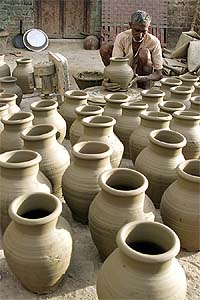A potter makes earthen pitchers at his workshop in Amritsar