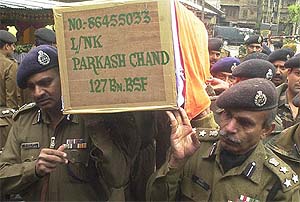 Senior paramilitary officers carry the body of Prakash Chand of Bilaspora of the BSF