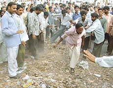 Sweepers throw garbage in front of the main gate of the Chandigarh Municipal Corporation office on Monday evening.