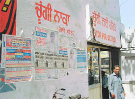 The side wall of octroi post outside the railway station stands almost entirely covered with posters