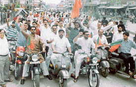 Activists of the Bharatiya Janata Yuva Morcha hold a scooter rally in protest against the decision of the government