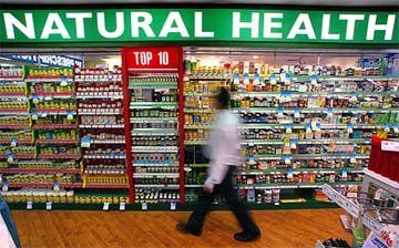 Store worker Sam Issa walks past rows of herbal, vitamin and mineral pill products