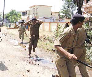 Bihar police personnel try to save themselves from anti-lathi rally activists