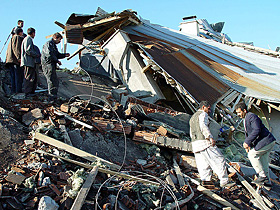 Men search through the debris of houses destroyed in an earthquake in the town of Celtiksuyu, near the southeastern Turkish town of Bingol