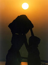 A labourer places a basket of sand