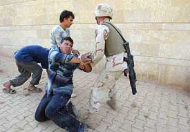 An American soldier handcuffs a teenager