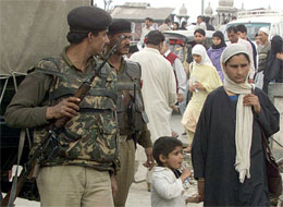 A soldiers guard a busy street