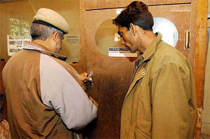 A police official seals the computer section of Kashmir Press Service