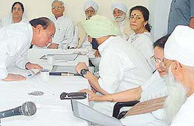 Punjab Chief Minister Amarinder Singh is all ears to Local Bodies Minister Jagjit Singh at the PPCC meeting in Chandigarh on Monday. 