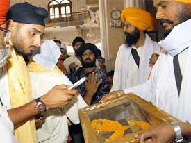Indian spinner Harbhajan Singh taking photographs by his mobile phone during his visit to Takht Sri Harmandirji