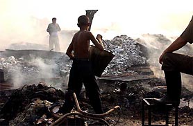 Local residents lend a helping hand in dousing the devastating fire that destroyed dwellings in the Yamuna Pusta slum in New Delhi 