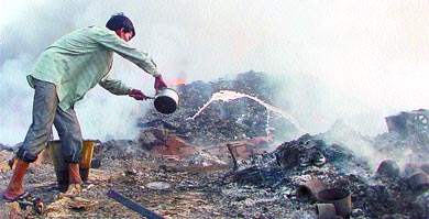 A resident trying to douse the fire at Yamuna Pushta in the Capital 