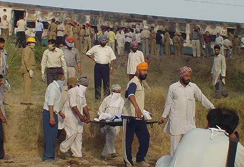 Villagers and rescue workers remove bodies from the train coaches.